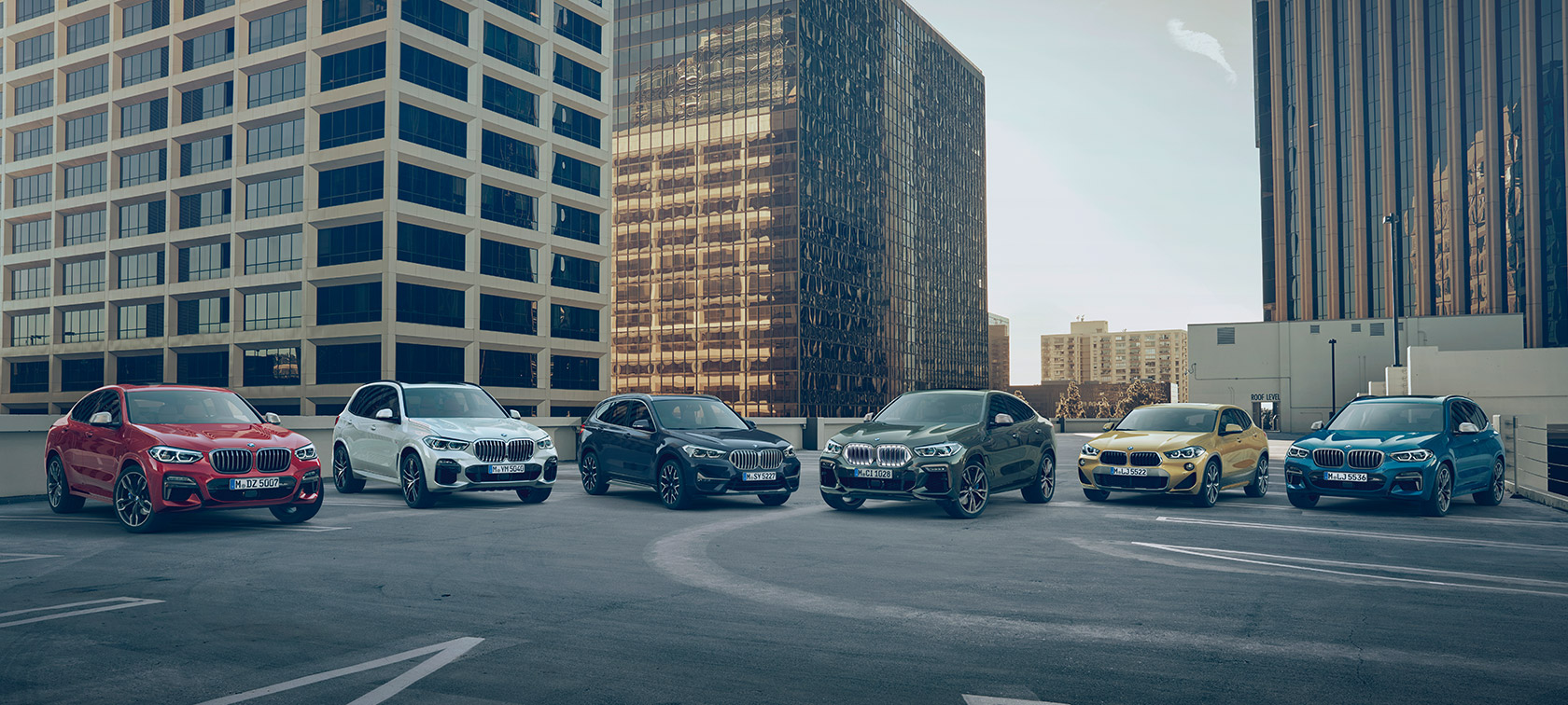 BMW X Fahrzeuge auf Parkdeck vor Gebäuden BMW X Modelle BMW X Fahrzeuge auf Parkdeck vor Gebäuden