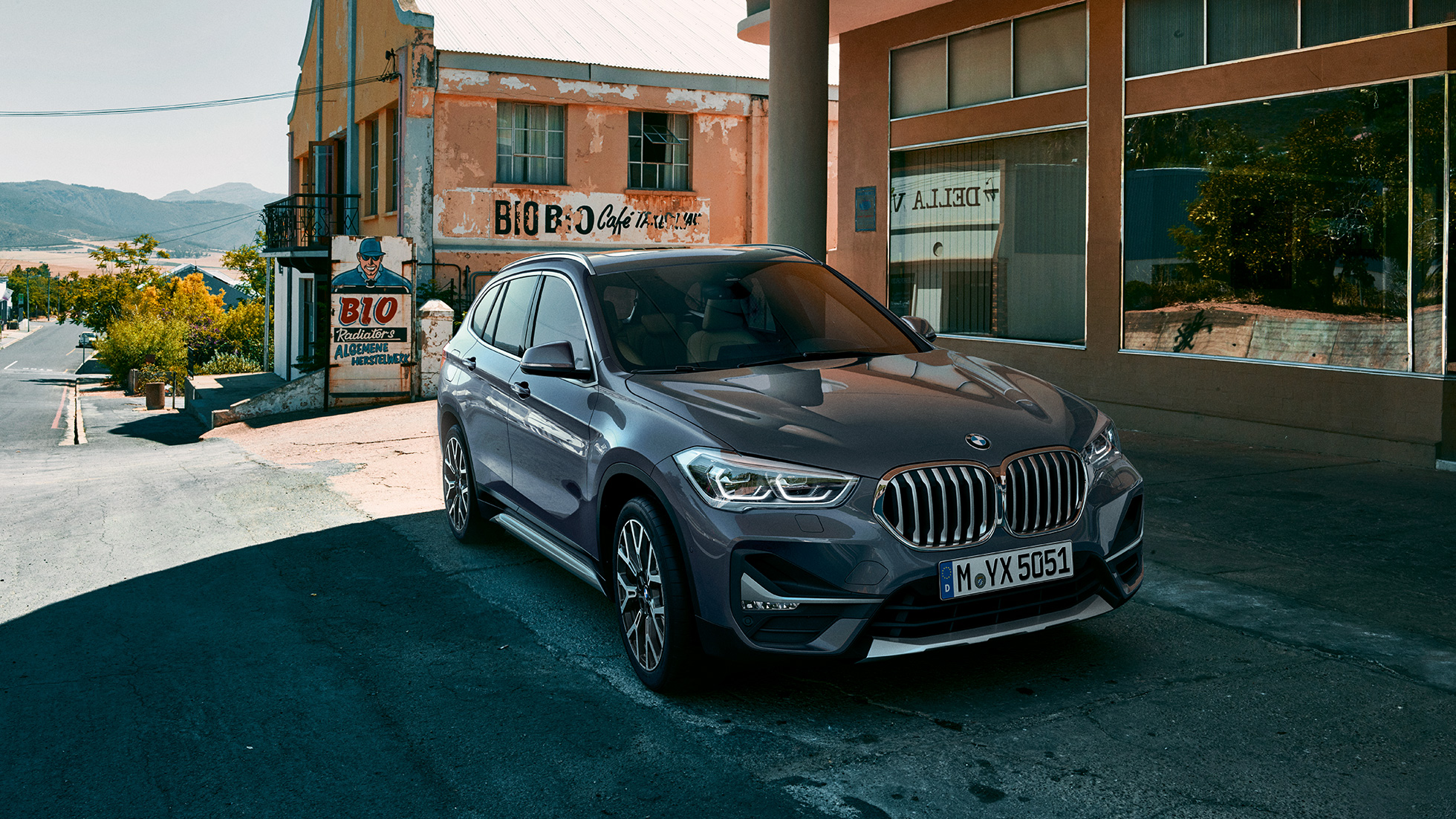 BMW X1, Dreiviertel-Frontansicht. BMW X1, Dreiviertel-Frontansicht steht vor urbaner Kulisse.