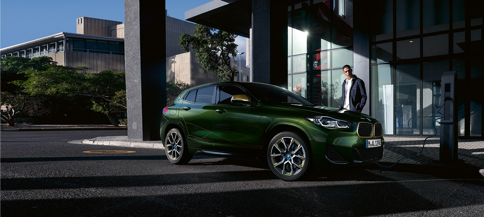 BMW X2 F39 Sanremo Green metallic Dreiviertel-Seitenansicht mit Model BMW X2 F39 Sanremo Green metallic Dreiviertel-Seitenansicht mit Model