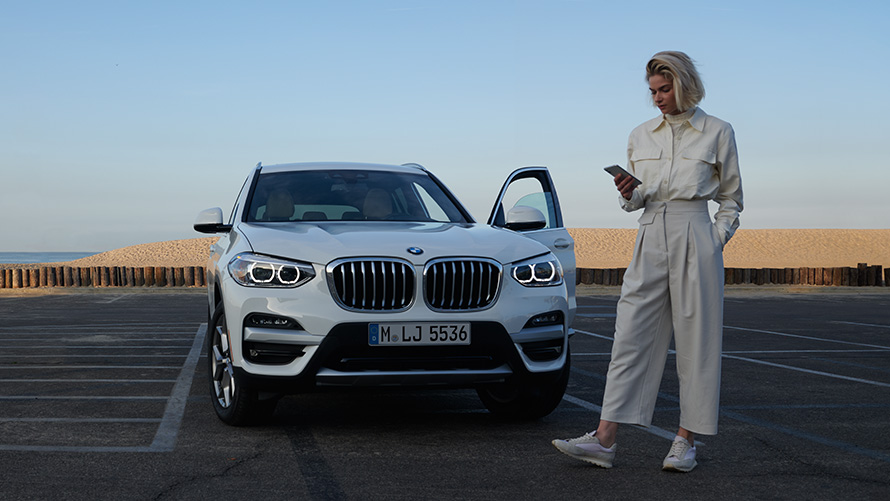 BMW X3 G01 Kataloge App Frau neben BMW 2021 BMW X3 G01 Kataloge App 2021