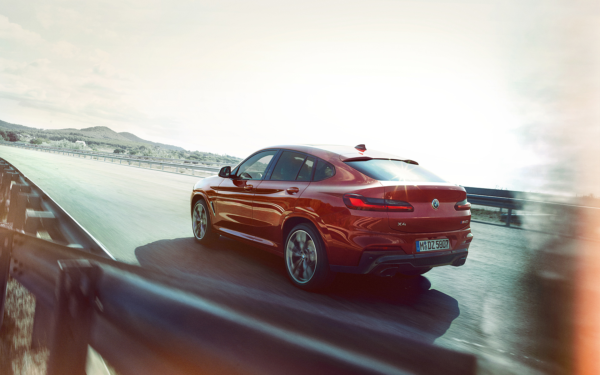 Fahrender BMW X4 rot - Rückansicht Fahrender BMW X4 rot - Rückansicht