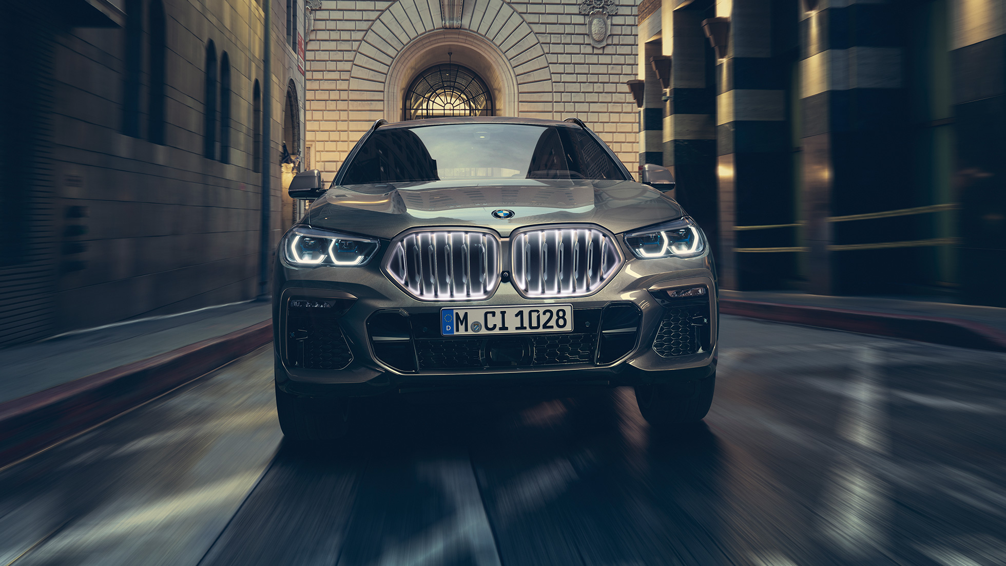 BMW X6 mit BMW Niere ‘Iconic Glow’. BMW X6 in Frontansicht vor urbaner Kulisse.