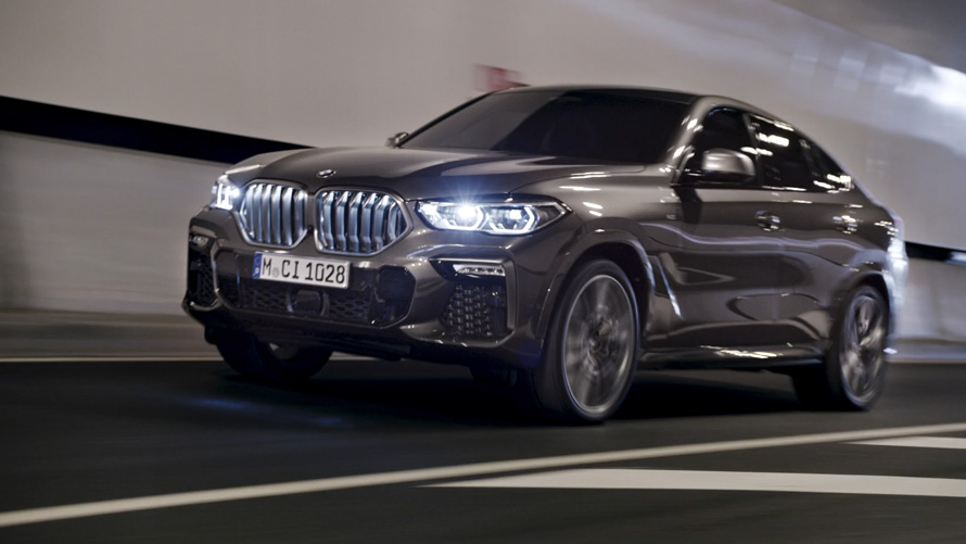 Dreiviertel-Frontansicht BMW X6 G06 2019 BMW X6 G06 2019 Dreiviertel-Frontansicht beim Fahren vor einer städtischen Kulisse