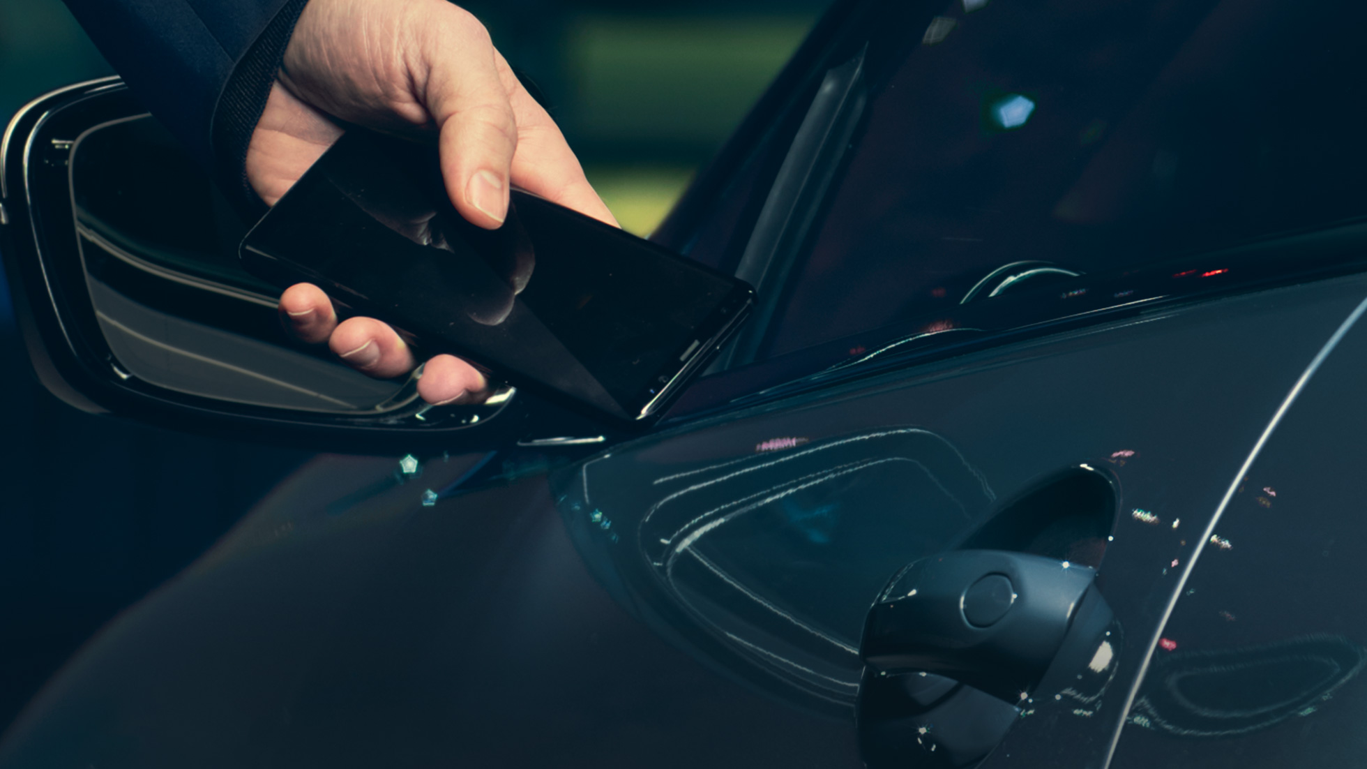 Digital Key Digital Key: Mann hält sein Smartphon von außen and die Fahrzeugtür