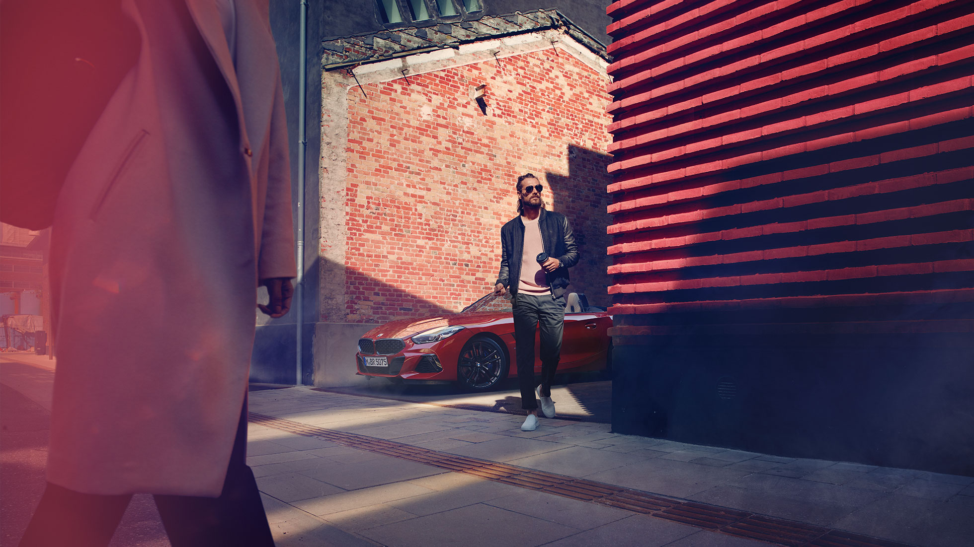 BMW Z4 Roadster in Seitenstraße Mann in Seitenstraße vor BMW Z4 Roadster