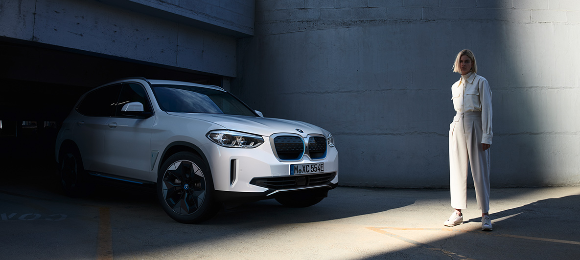 Frau vor BMW iX3 BMW EfficientDynamics Frau vor BMW i3