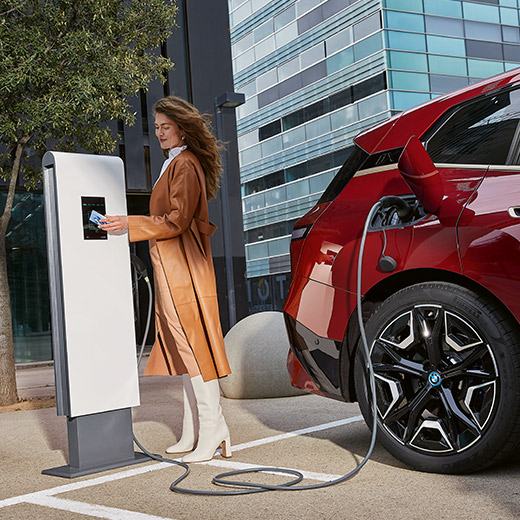 BMW iX i20 an Ladesäule BMW iX i20 an Ladesäule Frau mit BMW Charging Card