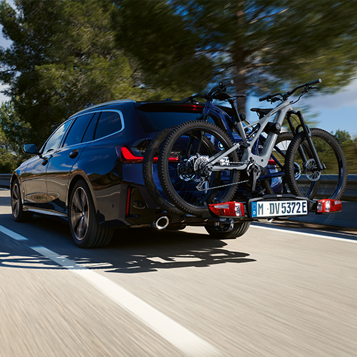 BMW 3er Touring G21 PHEV 3/4 Heckansicht mit Fahrrädern fahrend