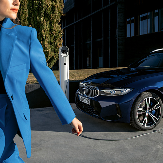 Ladesituation mit BMW gehende Frau im Vordergrund