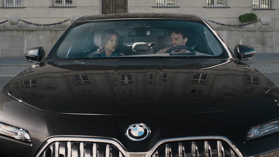 BMW iDrive Challenge Sightseeing BMW iDrive Challenge Sightseeing G70 Frontansicht zwei Personen schauen auf das BMW Curved Display