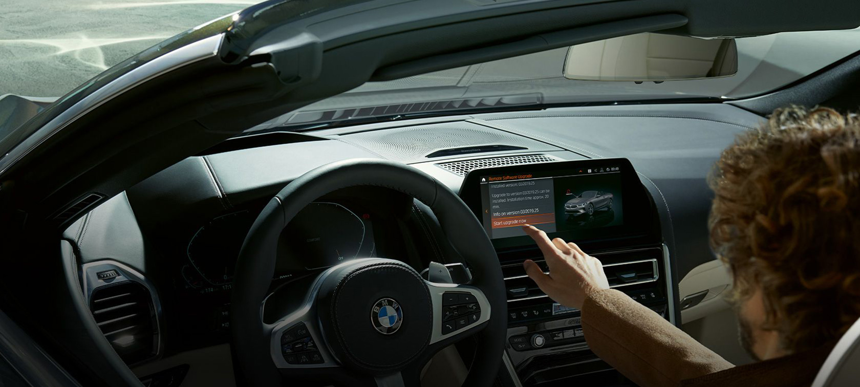 BMW Remote Software Upgrade Mann sitzt in BMW und startet BMW Remote Software Upgrade