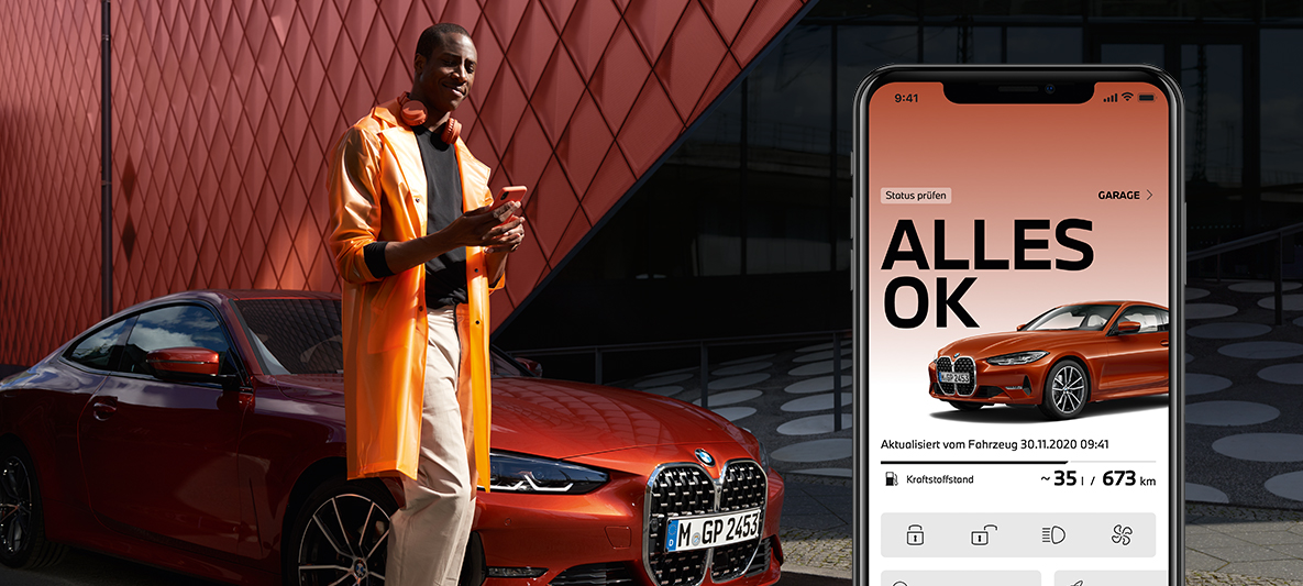 My BMW App Fahrzeugstatus checken Mann mit Smartphone vor BMW 2er Coupé My BMW App Fahrzeugstatus checken Mann mit Smartphone vor BMW 2er Coupé