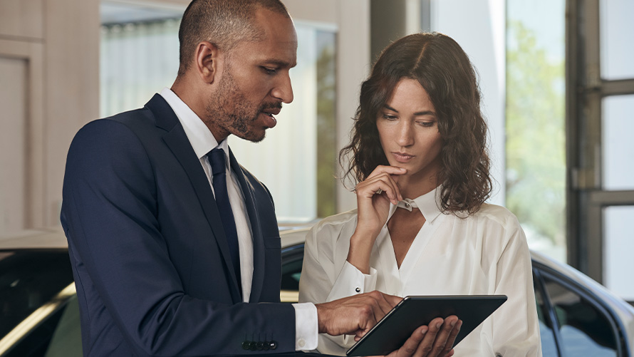BMW Gewährleistungs- verlängerung BMW Service Mitarbeiter erklärt BMW Service Kundin die BMW Gewährleistungsverlängerung