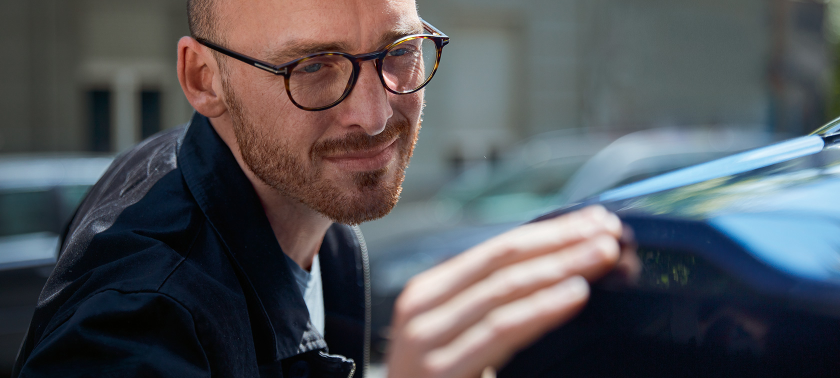 Ein Mann berührt gefühlvoll seinen BMW. Ein Mann berührt gefühlvoll seinen BMW.