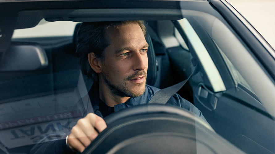 BMW Paket Care Mann am Steuer eines BMW
