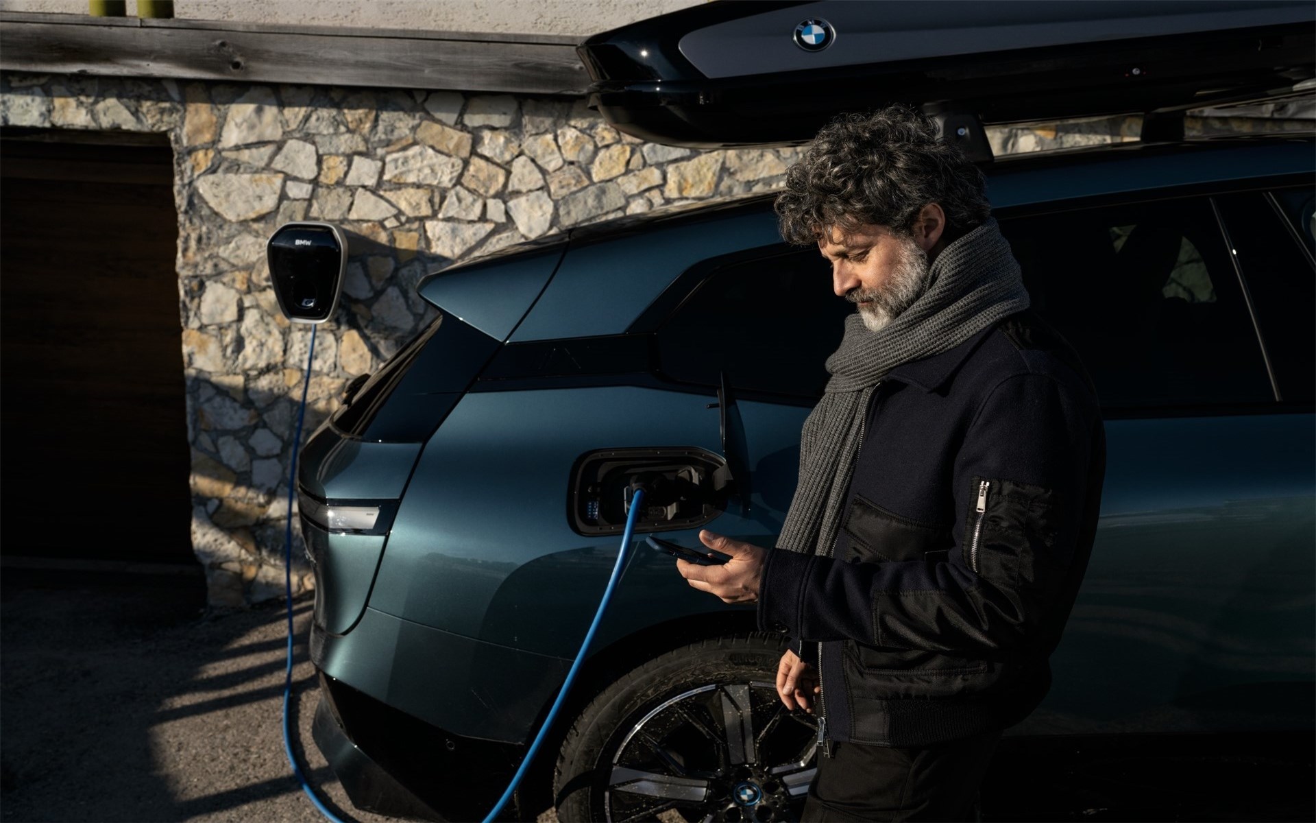 Laden zuhause BMW iX i20 Frau mit Smartphone