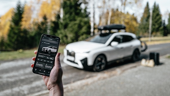 Mann sitzt in einem BMW und guckt auf sein Smartphone BMW Frühlings- und Sommerzubehör Mann sitzt in einem BMW und guckt auf sein Smartphone