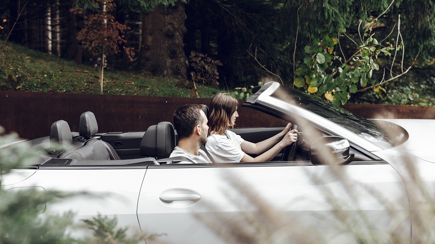 Mann lehnt an einem BMW vor Berglandschaft BMW Frühlings- und Sommerzubehör Mann lehnt an einem BMW vor Berglandschaft