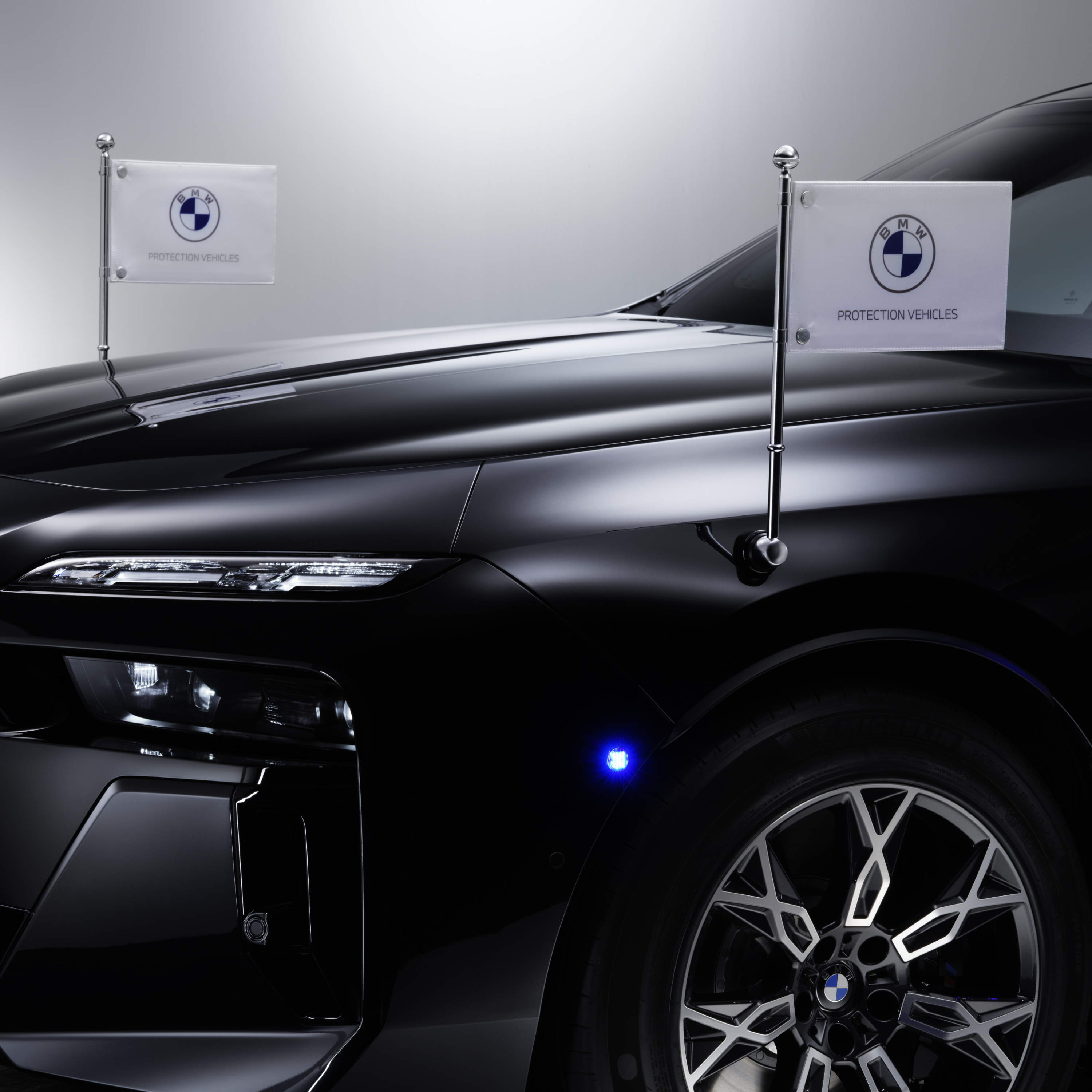 Ein BMW mit zwei Standartenhaltern vorn in Detailansicht