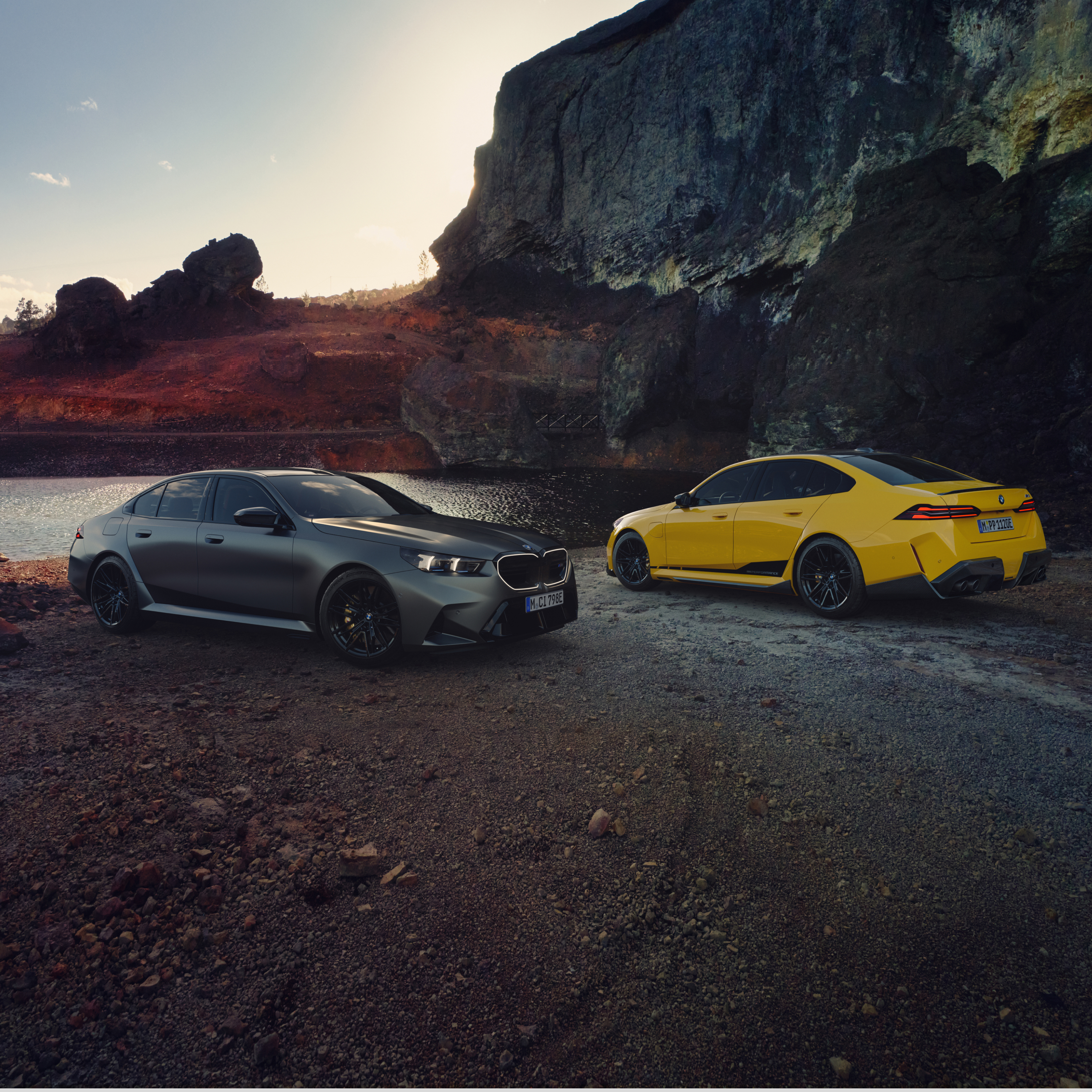 Zwei 5er BMWs stehen am Strand vor einer Felswand