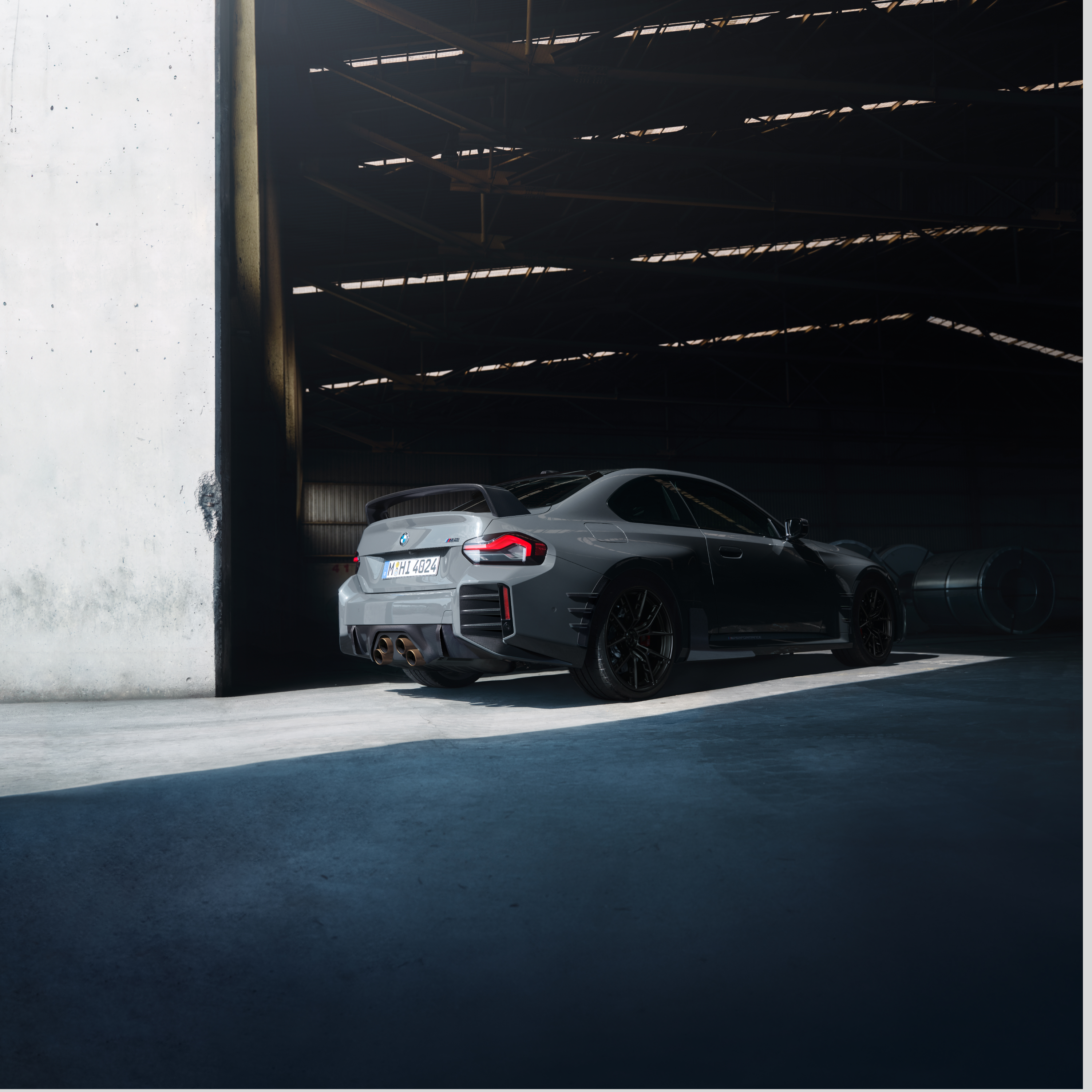 BMW steht vor dem Tor einer großen Halle