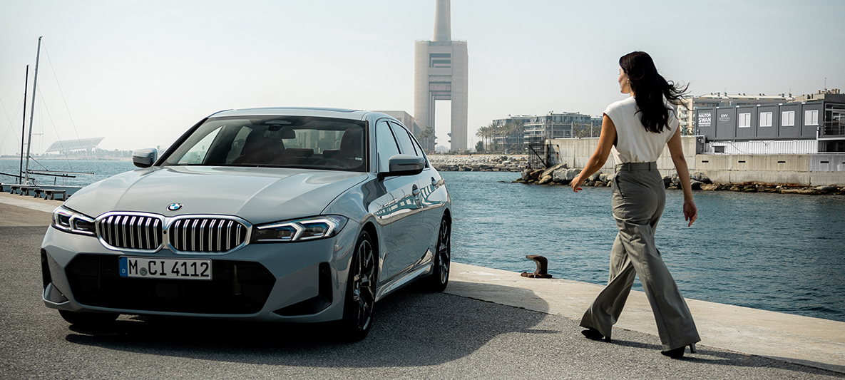 Eine Frau läuft auf ihren BMW zu.