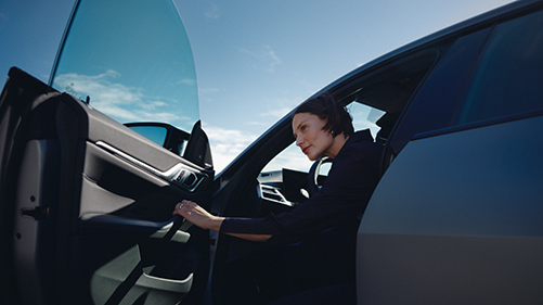Eine Frau öffnet die Tür ihres BMWs. Eine Frau öffnet die Tür ihres BMWs.